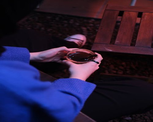 Seseorang menikmati secangkir kopi pagi di teras yang hangat